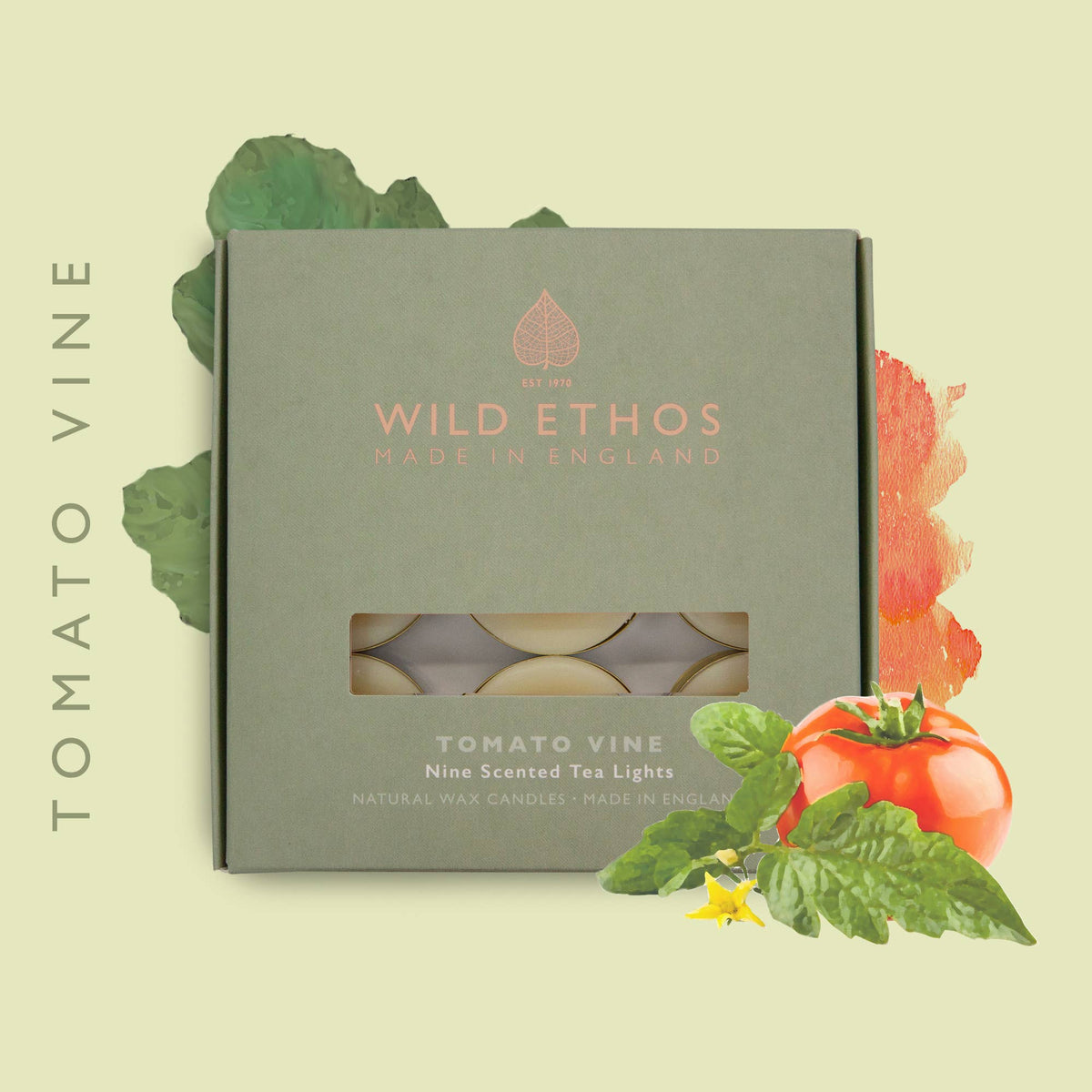 A rectangular product box for Wild Ethos Tomato Vine nine-scented tea lights sits on a pale yellow background with decorative tomato and basil illustrations. The box is muted sage green with rose-gold text and a window showing round tea light holders inside.