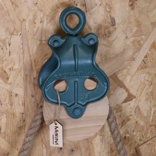 Blue pulley system with a tag on a wooden background