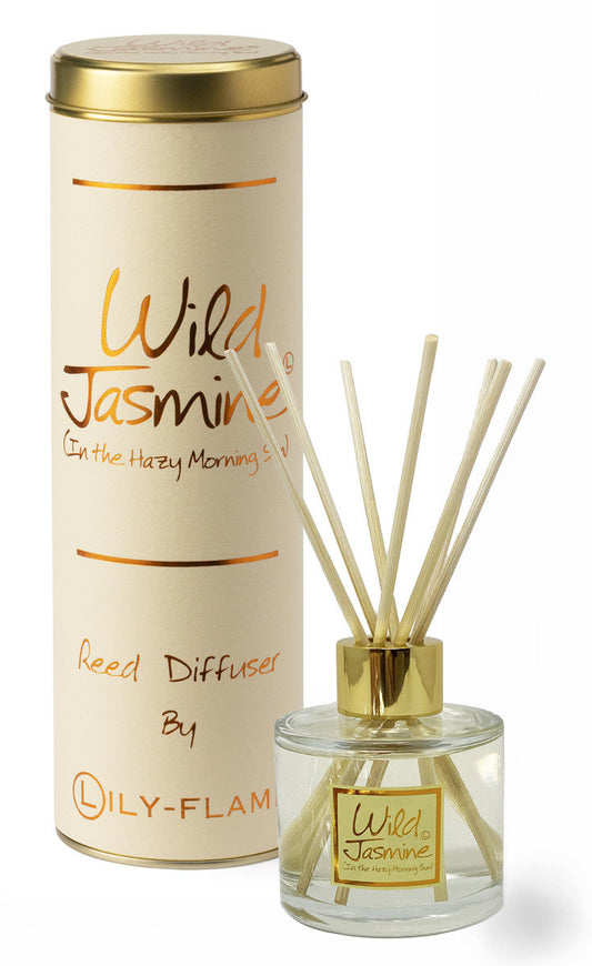 A reed diffuser set with a clear glass bottle, gold cap, beige reeds, and a tall cream cylindrical box with gold lettering reading Wild Jasmine by DILY-FLAM.