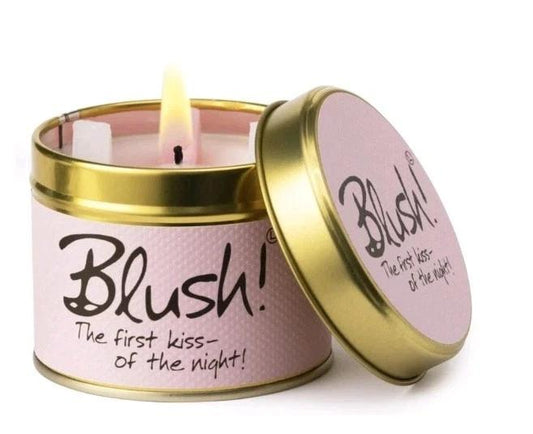 Candle in a pink tin labeled 'Blush!' with a gold lid on a white background