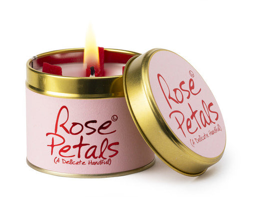 Candle in a pink tin labeled 'Rose Petals' with a gold lid on a white background