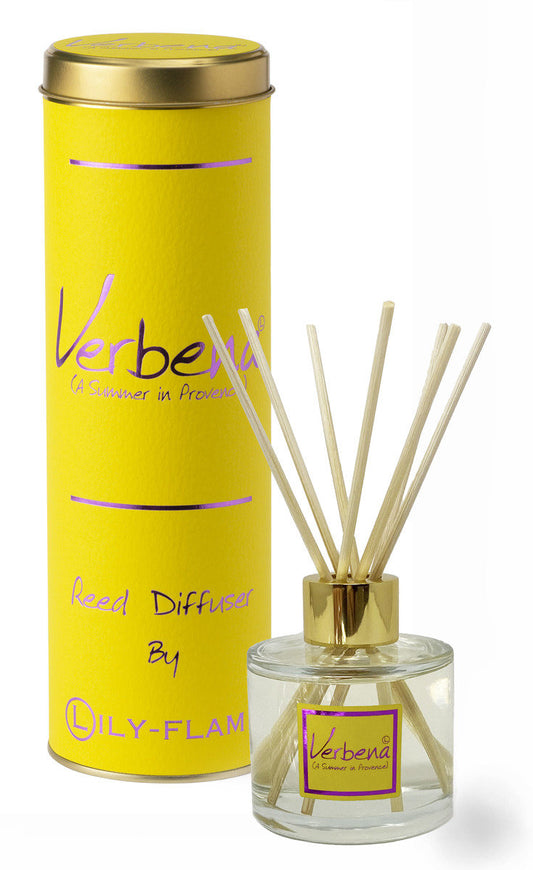 A yellow cylindrical reed diffuser tin with a gold lid stands behind a clear glass reed diffuser bottle with natural reeds and a gold cap. The packaging and bottle label read Verbená by DILY-FLAM.