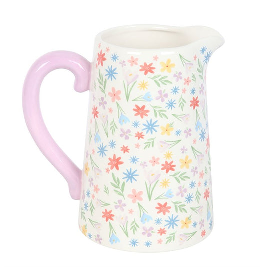 Pitcher with floral pattern and pink handle on a white background