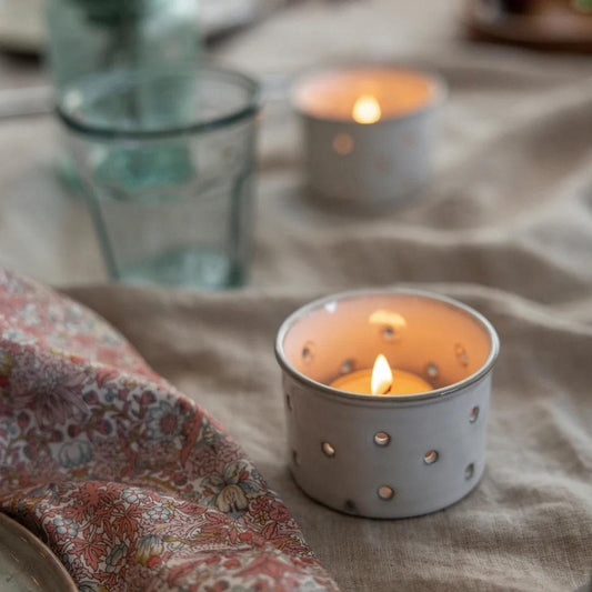 Candle in a decorative holder on a textured surface with a blurred background