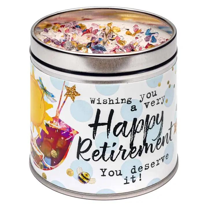 A tin candle with a 'Happy Retirement' design, featuring multicolored patterns and text on the label.