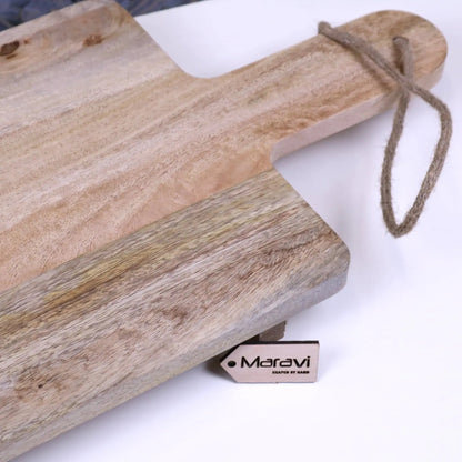 Wooden cutting board with a rope handle on a white surface, featuring the Maravi brand.