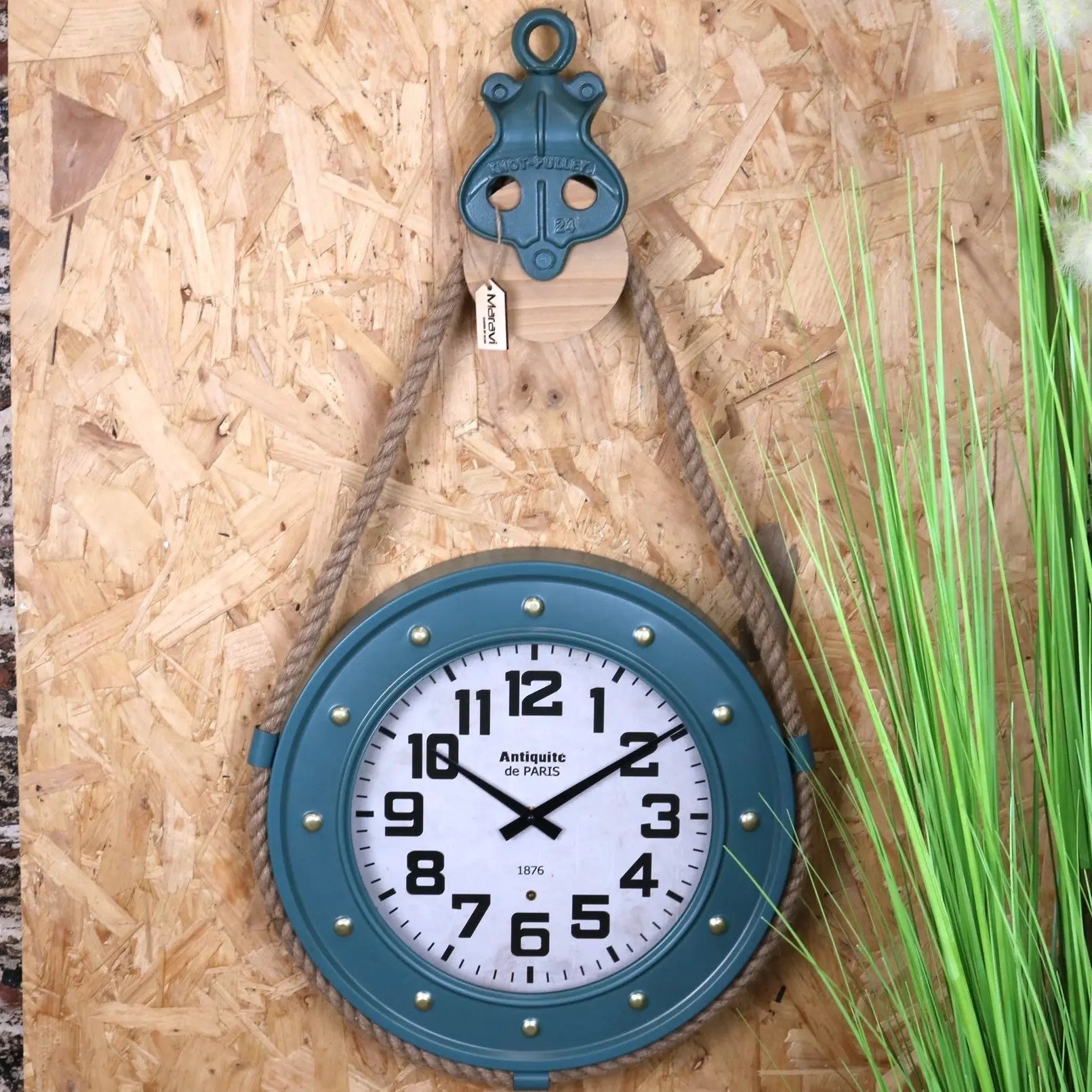 Blue wall clock with white face on a wooden background