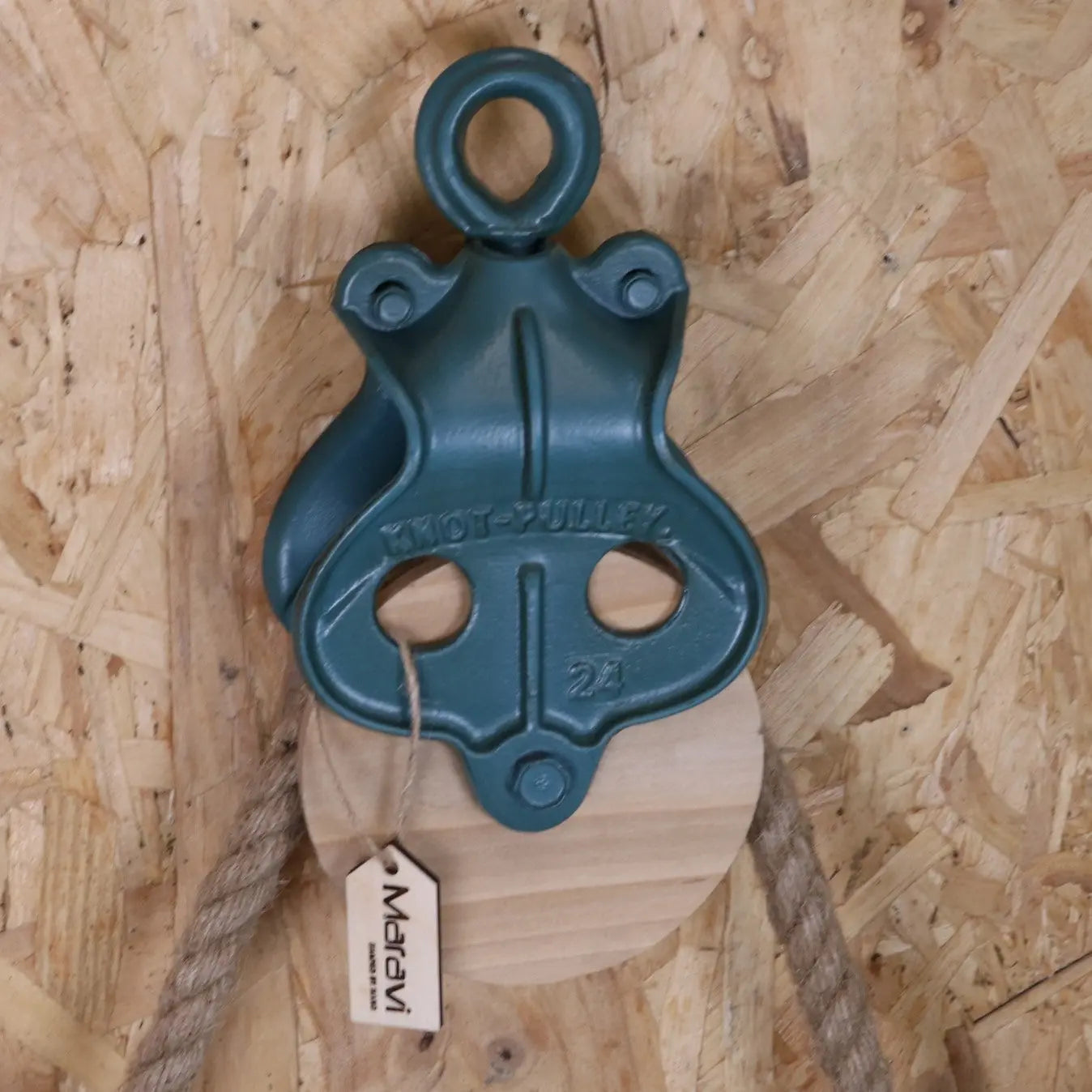 Blue pulley system with a tag on a wooden background