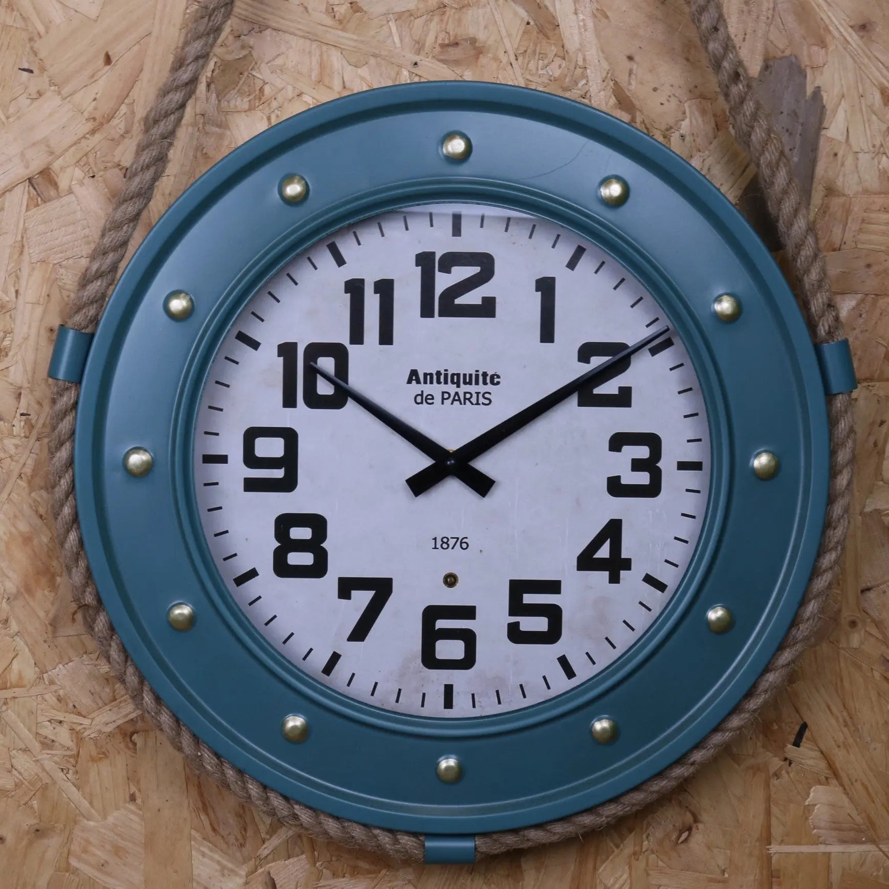 Wall clock with blue frame and white face on a wooden background