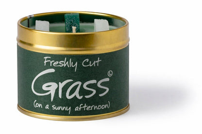 Candle in a tin labeled 'Freshly Cut Grass (on a sunny afternoon)' on a white background