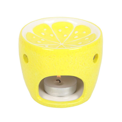 Yellow lemon-shaped candle holder with a lit tealight on a white background