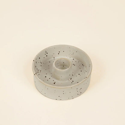 Speckled ceramic candle holder on a beige background
