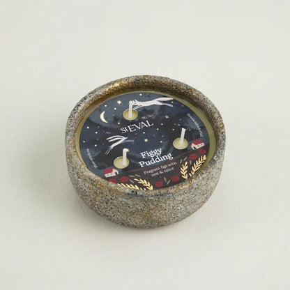 Candle with decorative label on a light gray background