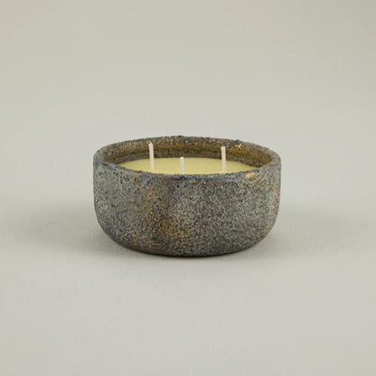Ceramic bowl with a candle inside on a plain background