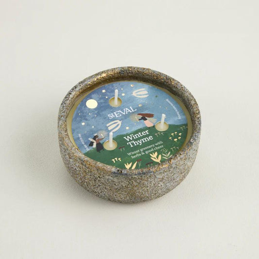 Candle with a decorative label on a light gray background