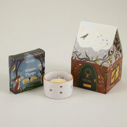 ST Eval Winter Thyme candle with packaging on a light gray background