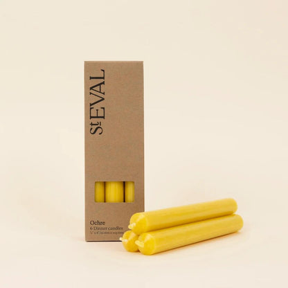 Yellow candles with a St Eval cardboard box on a beige background