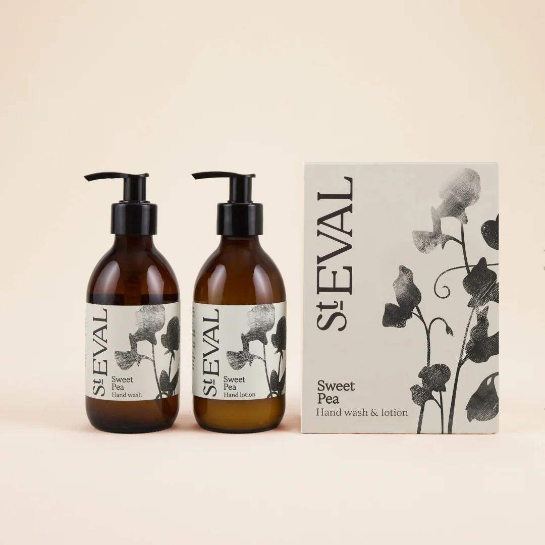 Two bottles of St. Eval Sweet Pea hand wash and lotion with a box on a beige background