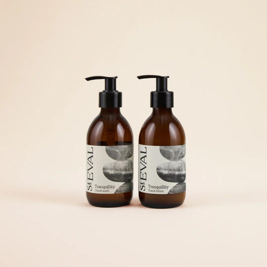 Two brown bottles with pump dispensers labeled 'ST Eval Tranquility' on a beige background.