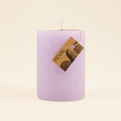 Purple candle with a 'ST eval' tag on a beige background