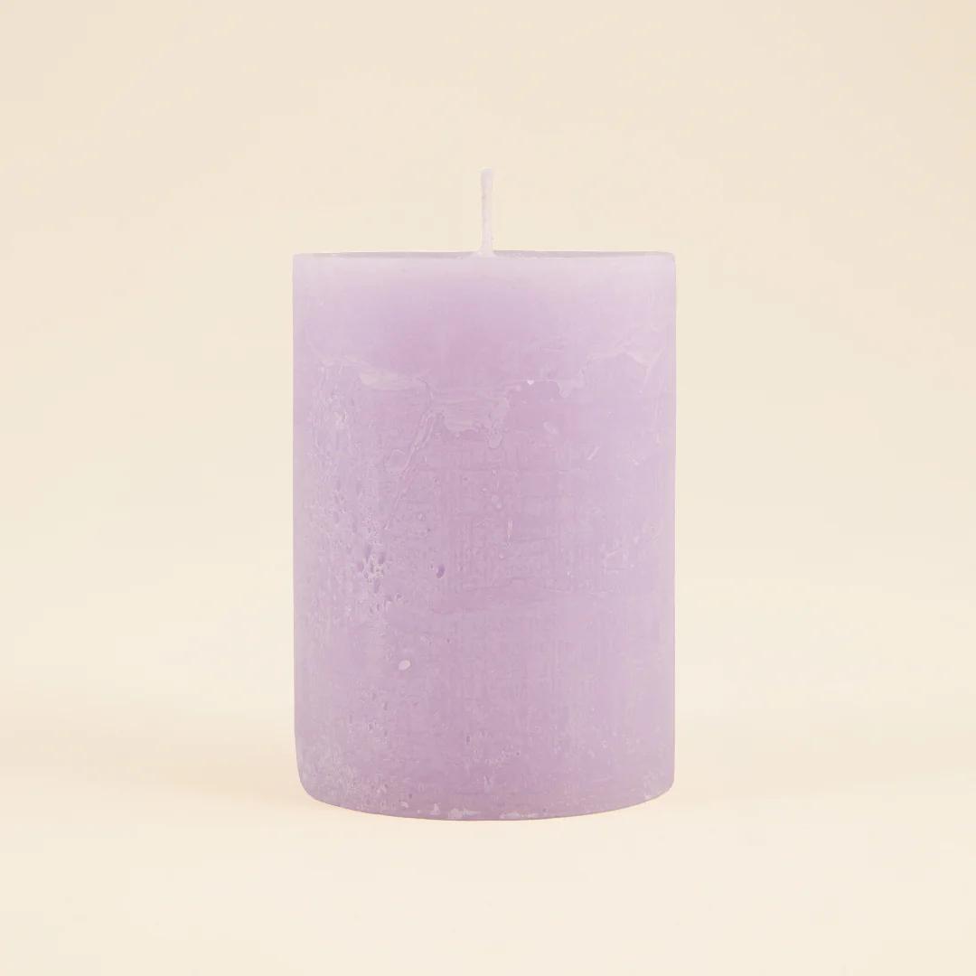Purple candle on a beige background