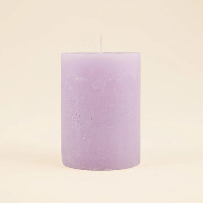 Purple candle on a beige background