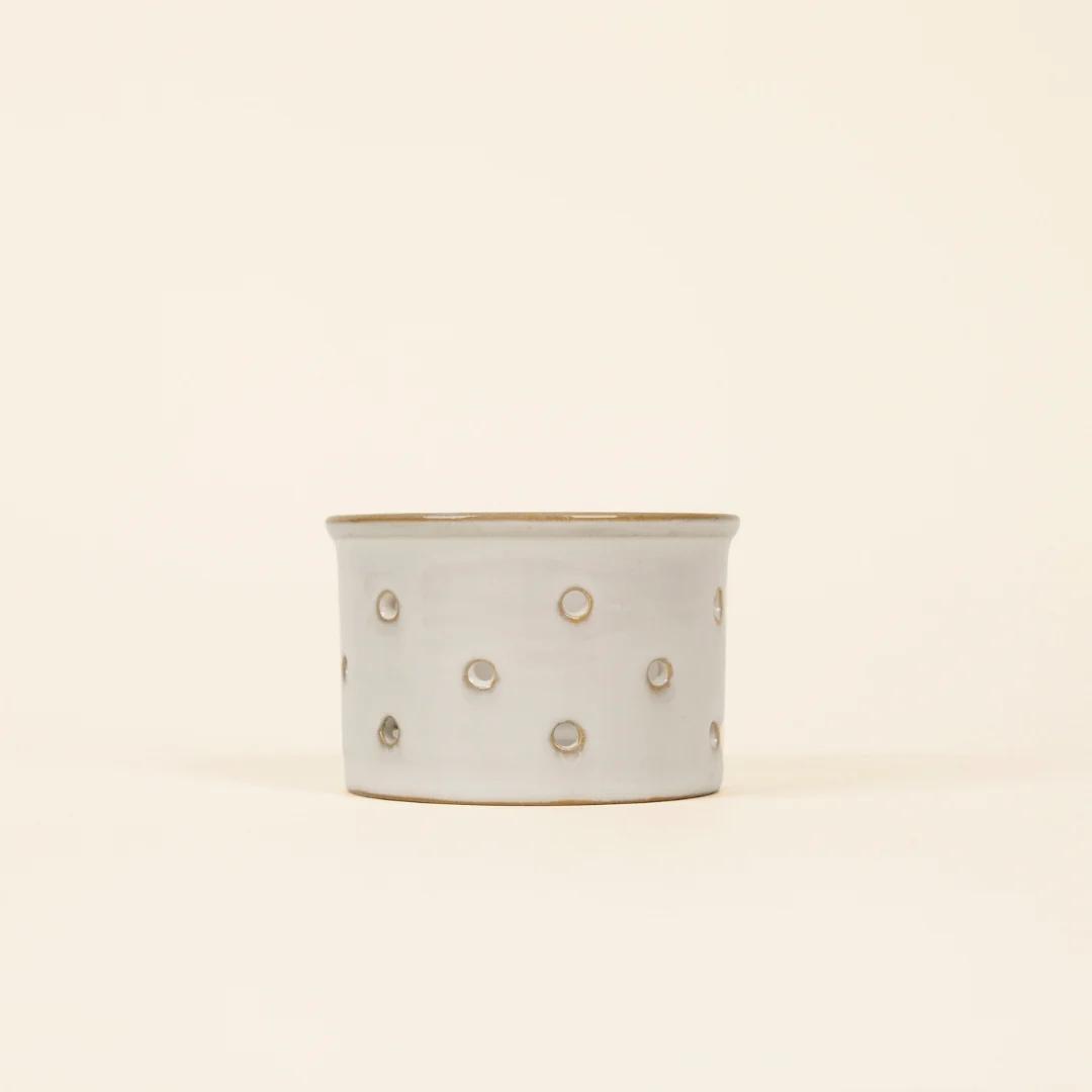 Ceramic planter with gold polka dot pattern on a beige background