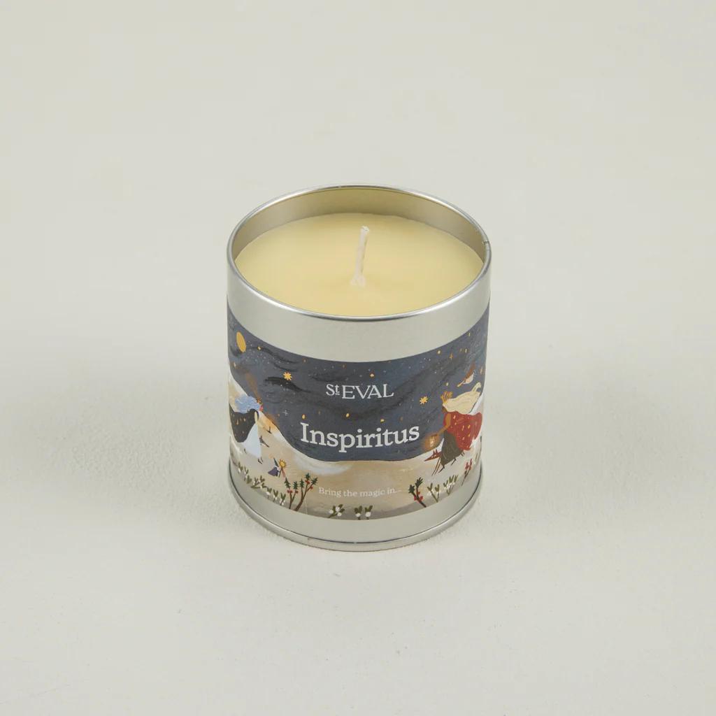 Candle in a metal tin labeled 'ST EVAL Inspiritus' on a light gray background