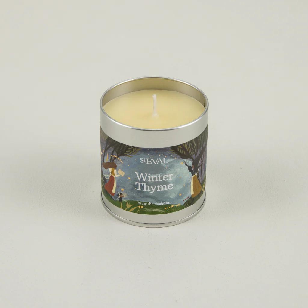 Candle in a tin labeled 'Winter Thyme' on a light gray background