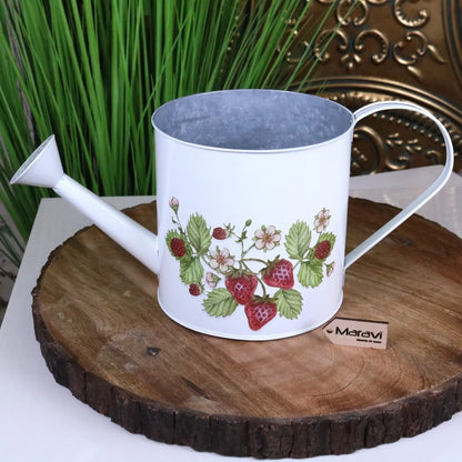 White watering can with strawberry design on a wooden surface, brand 'Maravi' visible