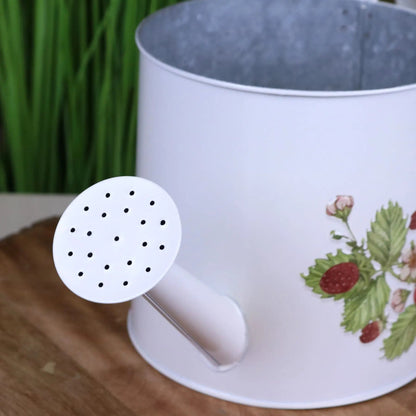White flowerpot with floral design on a wooden surface, featuring a close-up of a white plastic product with holes.