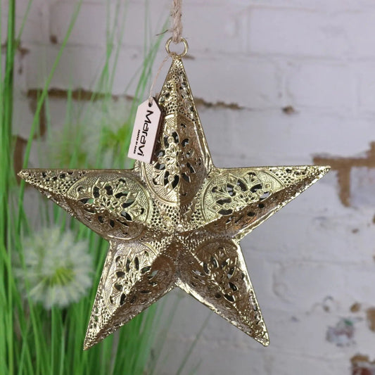 Decorative gold star hanging ornament with 'Makar' tag against a blurred natural background