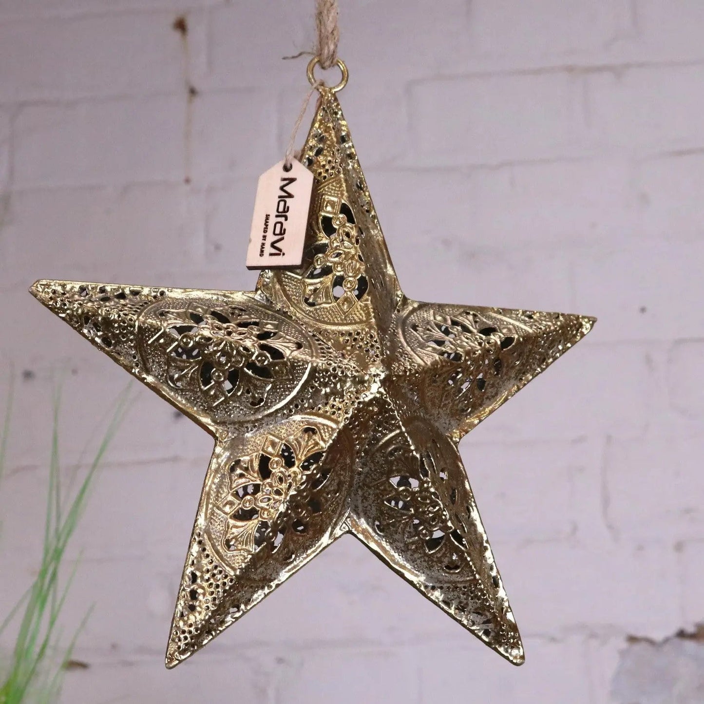 Decorative gold star ornament with intricate patterns on a light background