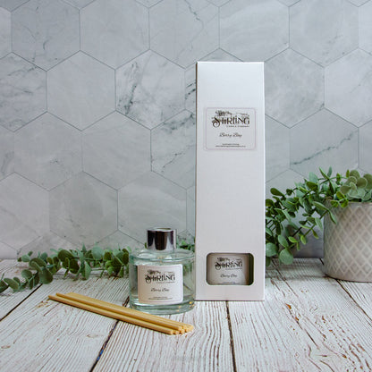 Berry Bay diffuser with packaging and sticks on a wooden surface with a marble wall background